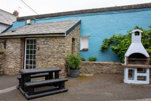 库姆马丁Yetland Farm Holiday Cottages的一座带长凳和鸟屋的蓝色建筑