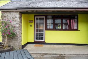 库姆马丁Yetland Farm Holiday Cottages的黄色的房子,有门和窗户