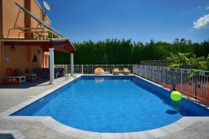 罗达Villa Jolie Corfu Roda的一座房子前面的蓝色海水游泳池