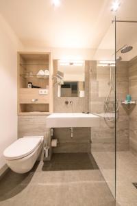 诺德奈Michels Inselhotel Vier Jahreszeiten的一间带水槽、卫生间和淋浴的浴室