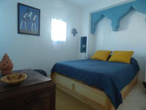 西迪伊夫尼Janna d'Ifni的一间卧室配有一张带蓝色床单和黄色枕头的床。