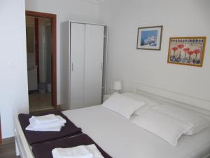波达卡Villa Falcon的卧室配有白色床和毛巾