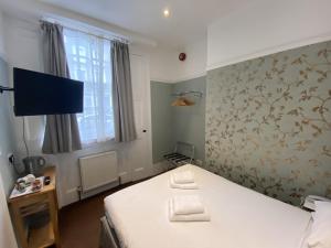 伦敦斯文顿酒店的一间卧室配有一张床和一台电视。