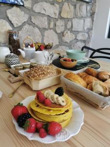 卢瓦尔河畔新堡Villa Moya, dependance privée Piscine & Spa的一张桌子,上面放着一大堆糕点、水果和面包