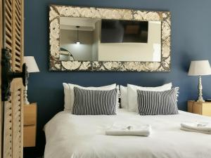 贝尔维尔爱克塞伦特旅馆的卧室配有大镜子,位于床上方