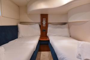加亚新城Sailing 360 Night On Board Experience的小型客房配有两张床和一张桌子。