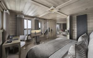 谷雪维尔Hotel Le K2 Altitude的一间带一张大床和一张书桌的卧室和一间房间