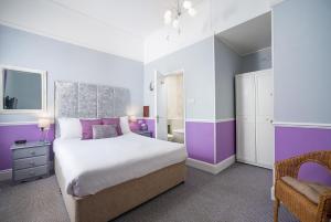 托基The Mariners - Torquay的紫色和白色的卧室,配有一张床和一把椅子