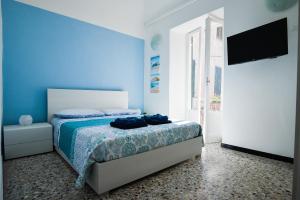 诺利La Zuacca, luminoso appartamento con terrazzo的蓝色卧室配有床和平面电视