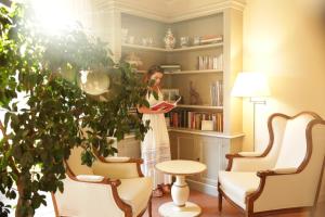 东塞斯特里阿格尼斯别墅酒店的站在客厅里种植植物的女人