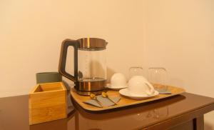 佩鲁贾Umbrian Concierge - Alla Rocca的一个带咖啡壶和桌子上眼镜的托盘