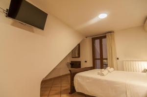 佩鲁贾Umbrian Concierge - Alla Rocca的卧室配有一张床,墙上配有电视。