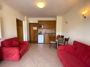马尔马里斯Club Karakas Apart Otel的一间带两张红色沙发的客厅和一间厨房