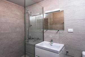 马塔拉royal nest的一间带水槽和玻璃淋浴的浴室