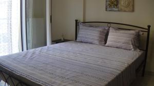 塞雷Anastasia's & Despoina's Apartment的一张带蓝色和白色毯子的床和一个窗口