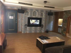 土城区探索(探情)汽车旅馆-土城馆的客厅的墙上配有电视