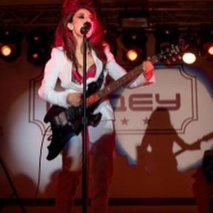 库斯塔奈麦迪奥酒店的戴着红发的女人在舞台上弹吉他