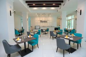瓜拉江沙Hotel Casuarina@Kuala Kangsar的一间配备有桌子和蓝色椅子的用餐室
