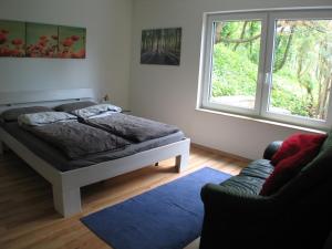 ZierenbergFerienwohnung in Waldrandlage的一间卧室设有床、窗户和沙发