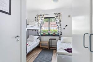 韦灵厄Bruksparkens Hostel的小房间设有两张双层床和窗户