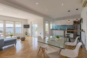 赫瓦尔Apartment Shades of Blue的厨房以及带玻璃桌和椅子的客厅。