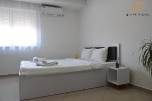 雅戈丁那S-Apartmani Cocetova的白色卧室设有一张带窗户的床
