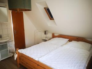 霍瓦赫特Ferienwohnungen und Ferienhaus im Nixenweg的卧室配有白色的床和水槽