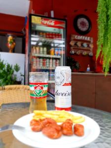 马卡埃Pousada Solar dos Cavaleiros Mendes的一张桌子,上面放着一盘食物和一杯啤酒
