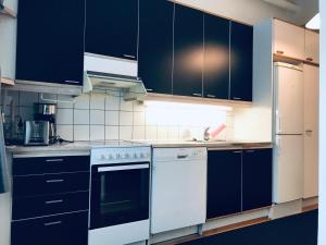 赫尔辛基Kamppi City Apartment的厨房配有黑色橱柜和白色家电