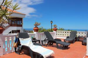 Monte de BreñaCasa Los Palitos的一个带椅子和白色围栏的庭院和大海