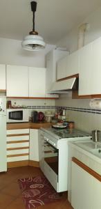卡波罗纳Home Azzurra的厨房配有白色橱柜和炉灶烤箱。