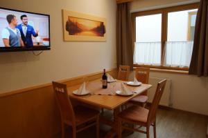 盖洛斯Haus Dorfblick的一间设有桌子和墙上电视的用餐室