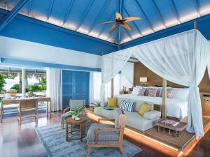 加弗阿利夫环礁Raffles Maldives Meradhoo的一间卧室设有一张床和一间客厅。