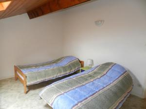 比斯卡罗斯海滩Les Flots Bleus Etage的墙上的房间里设有两张床
