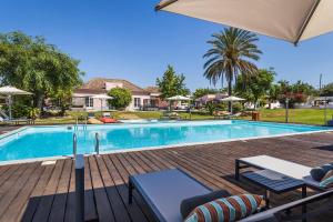 塔维拉Quinta de Santa Margarida - Charm Country House的一个带椅子和遮阳伞的游泳池