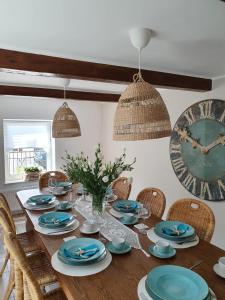 亚斯塔尔尼亚PATYKIEM PO WODZIE的用餐室配有木桌、椅子和时钟