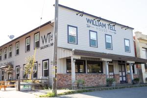 TomalesWilliam Tell House的一座建筑物,上面有标志,上面写着威廉第一家的书