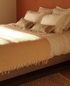 圣佩尔港Le Grand Jardin的一张带白色床单和枕头的床