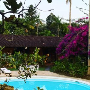 佩尼多佩妮多旅馆的紫色花卉花园中的游泳池