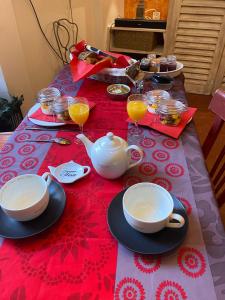 鲁西永Maison d'hôtes Une hirondelle en Provence的红色桌布上带茶具的桌子