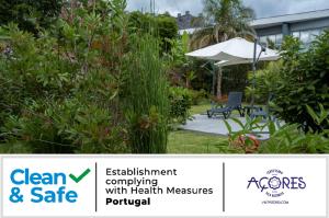 坎普自由鎮Casa da Quinta的一个带长凳和遮阳伞的花园标志