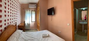 塞塞尼亚Hostal Seseña的一间卧室配有一张床、一个水槽和一台电视