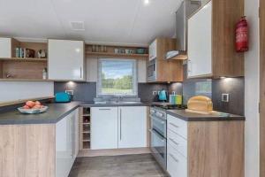 纽基Premium Chalet at Newquay Away Resorts MV7的厨房配有白色家电和木制橱柜