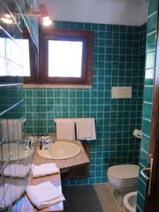 孔卡尔德康卡维德酒店的绿色瓷砖浴室设有水槽和卫生间