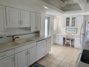 西耶斯塔岛Island House Beach Resort 5S的厨房配有白色橱柜、水槽和椅子