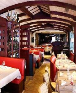 康卡勒米尔山普伦酒店的一间设有白色桌子和红色椅子的餐厅
