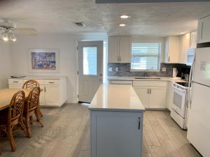 西耶斯塔岛Island House Beach Resort 32的厨房配有白色家电和桌椅