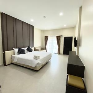 芭堤雅市中心The Shade Residence的卧室配有一张白色大床和电视。