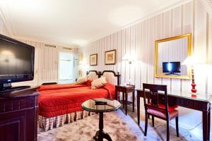 巴黎金色郁金香华盛顿剧院酒店的客厅配有红色的床和电视