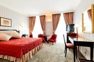 巴黎金色郁金香华盛顿剧院酒店的一间卧室配有红色的床、一张桌子和椅子